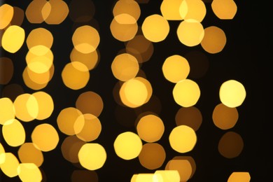 Photo of Blurred view of golden lights on black background. Bokeh effect