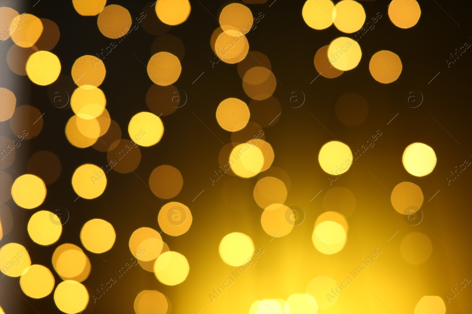 Photo of Blurred view of golden lights on dark background. Bokeh effect