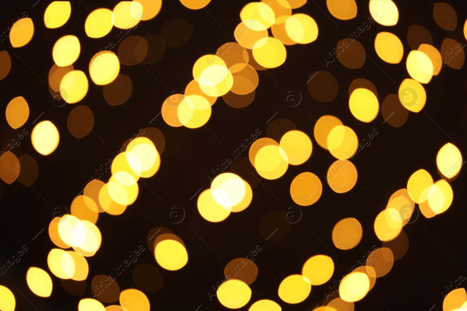 Photo of Blurred view of golden lights on dark background. Bokeh effect