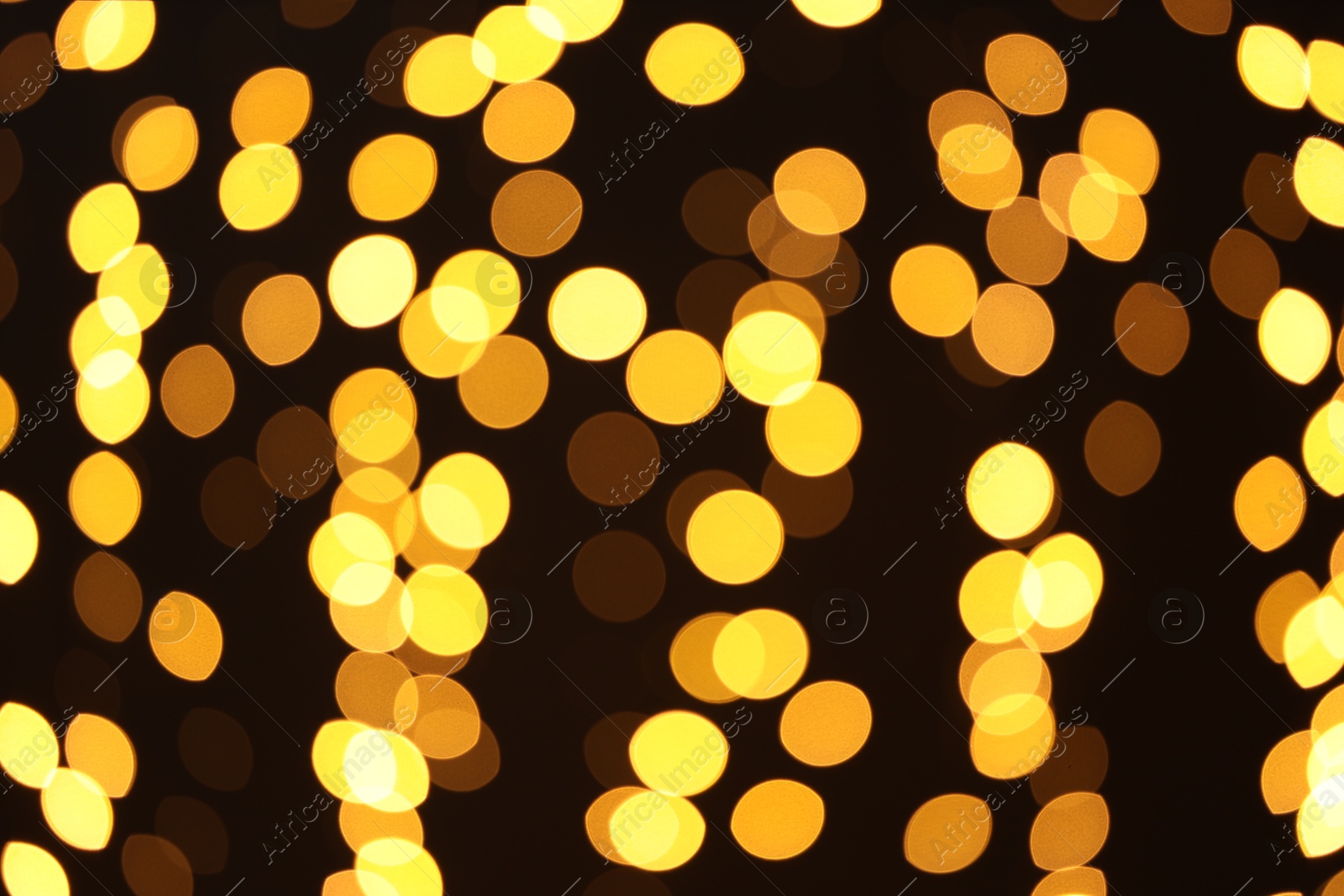 Photo of Blurred view of golden lights on dark background. Bokeh effect