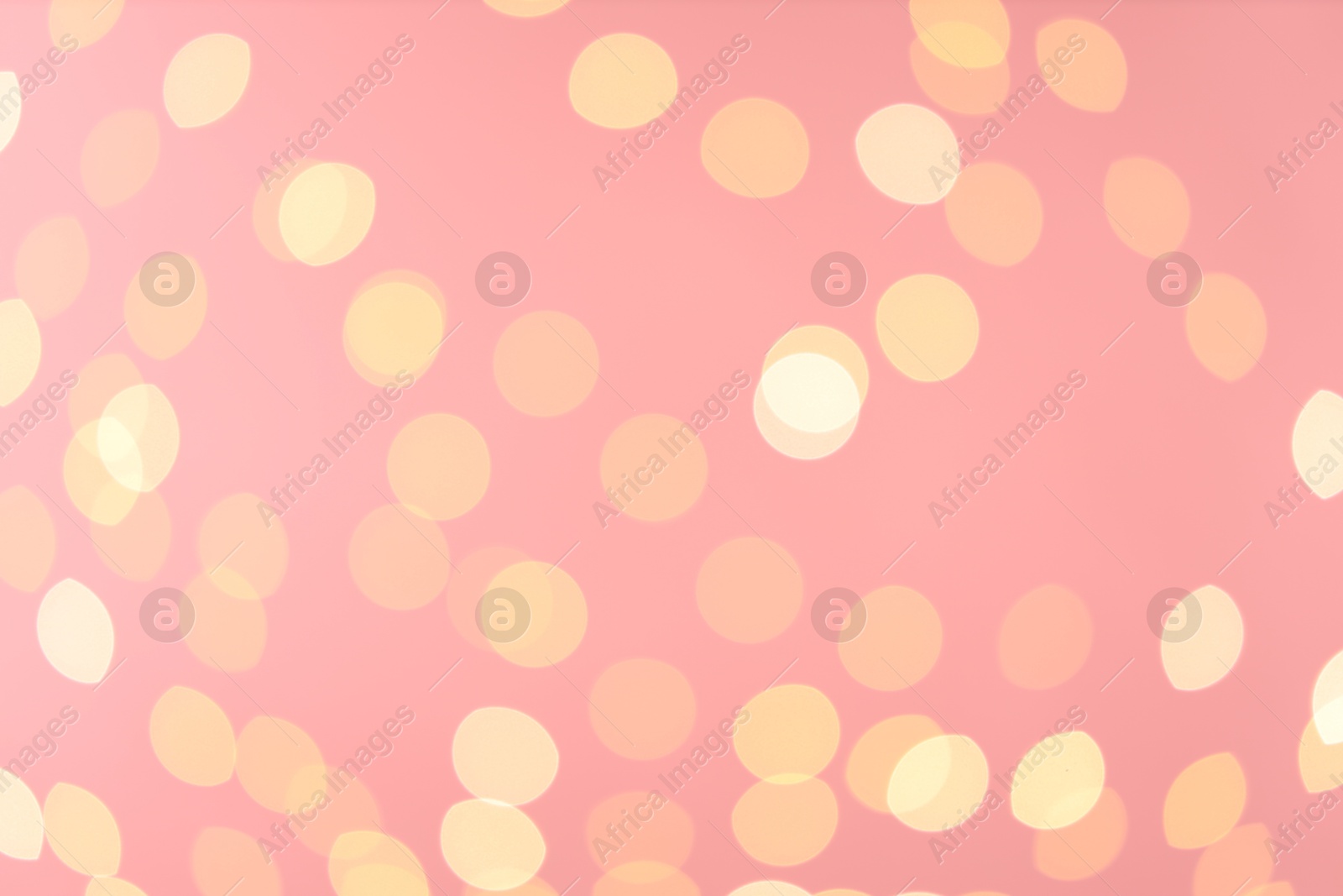 Photo of Blurred view of golden lights on pink background. Bokeh effect