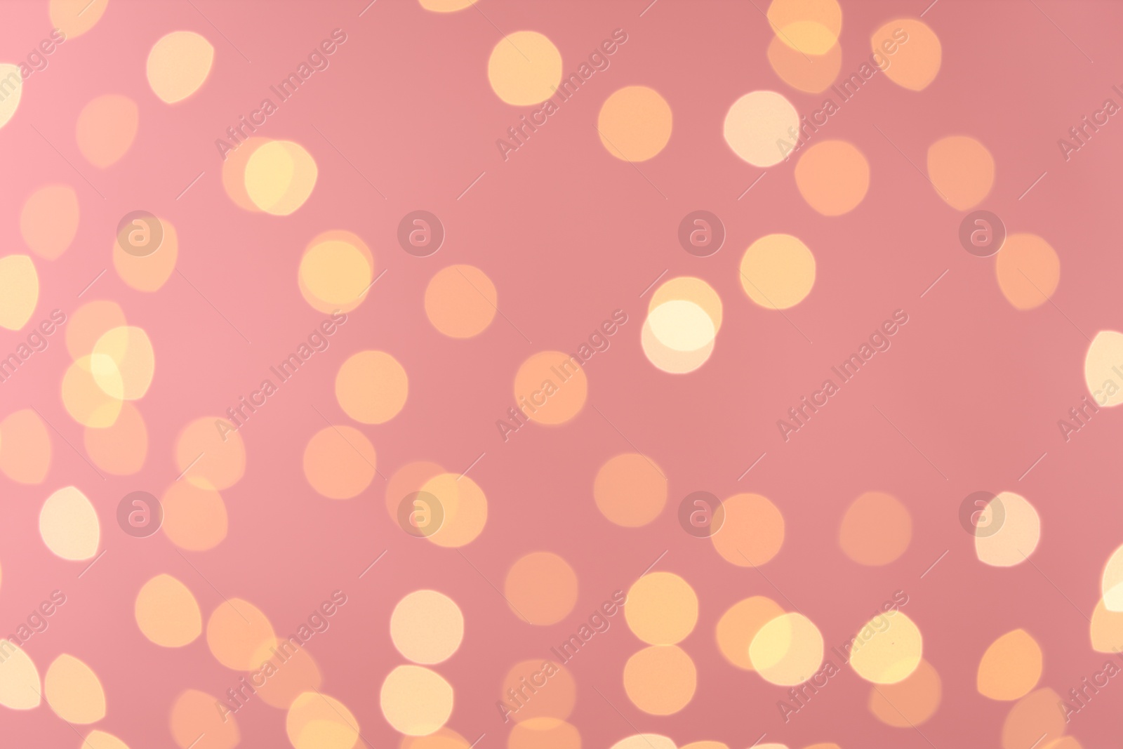 Photo of Blurred view of golden lights on pink background. Bokeh effect