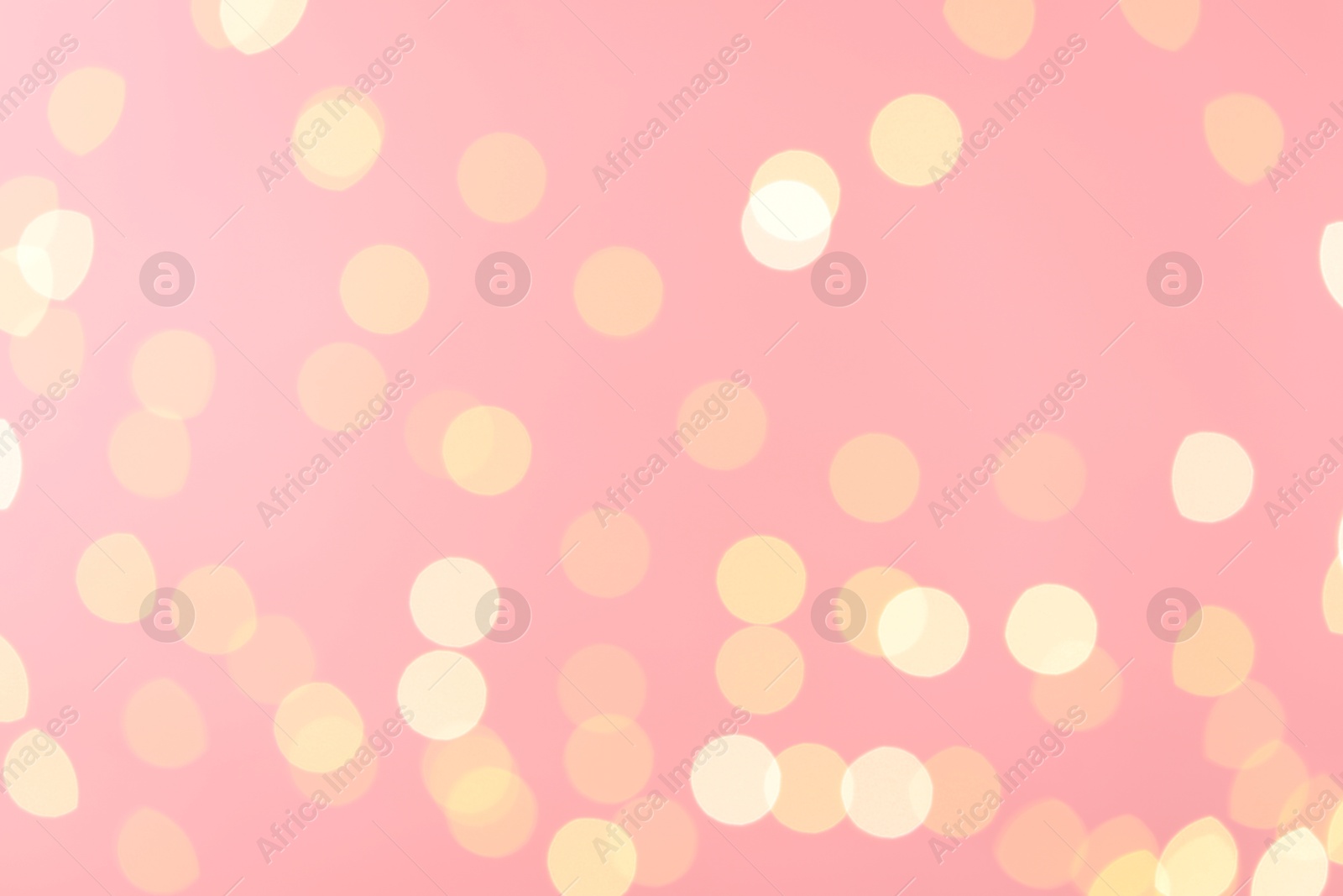 Photo of Blurred view of golden lights on pink background. Bokeh effect