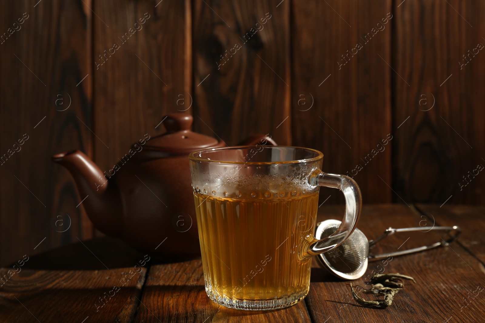 Photo of Refreshing green tea in cup on wooden table, closeup