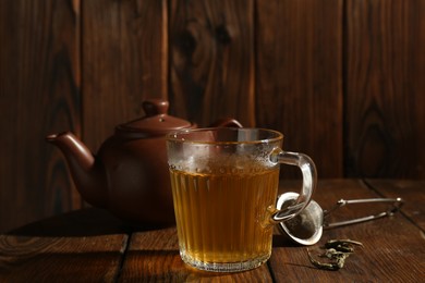 Photo of Refreshing green tea in cup on wooden table, closeup