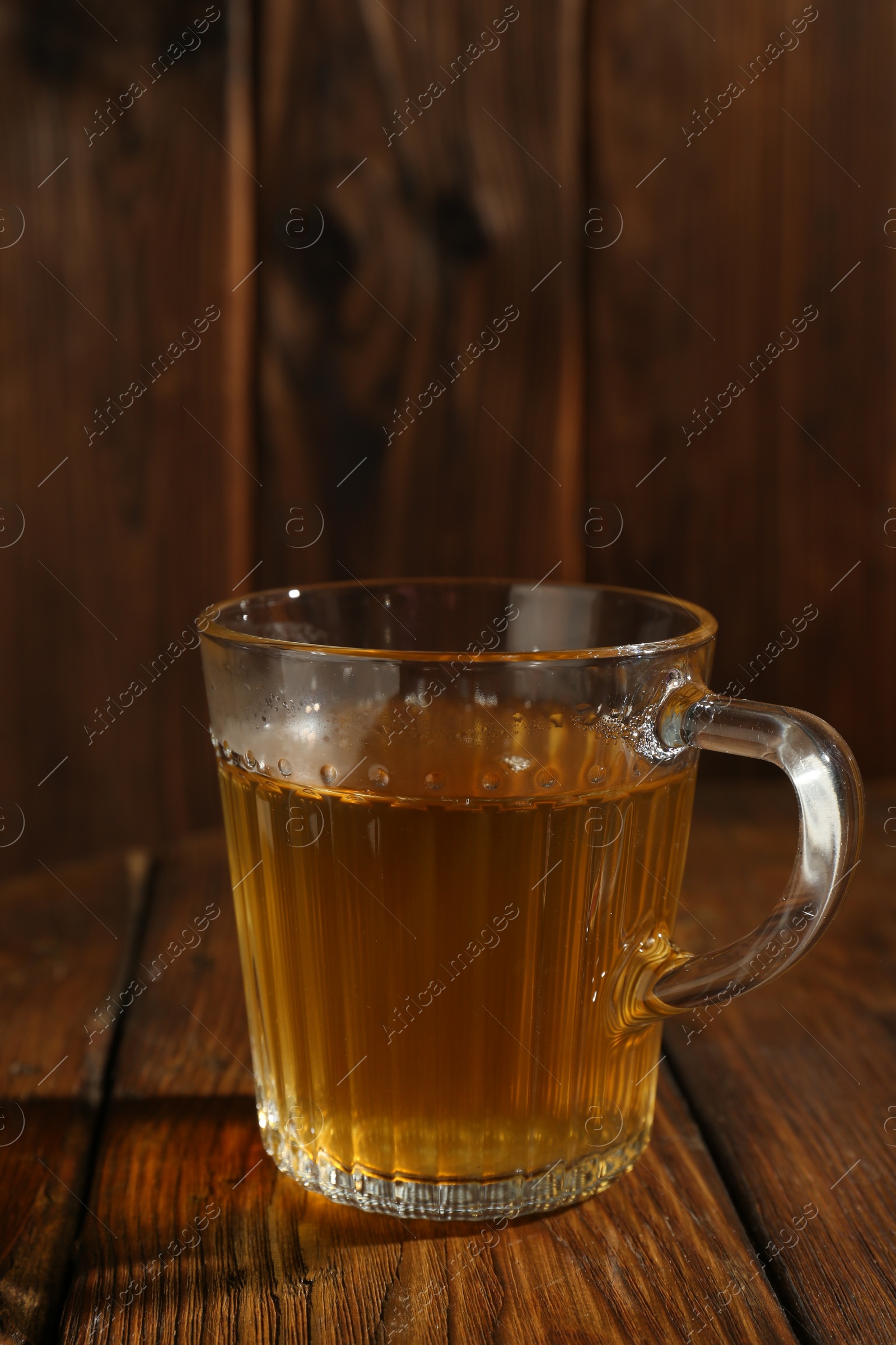 Photo of Refreshing green tea in cup on wooden table, closeup