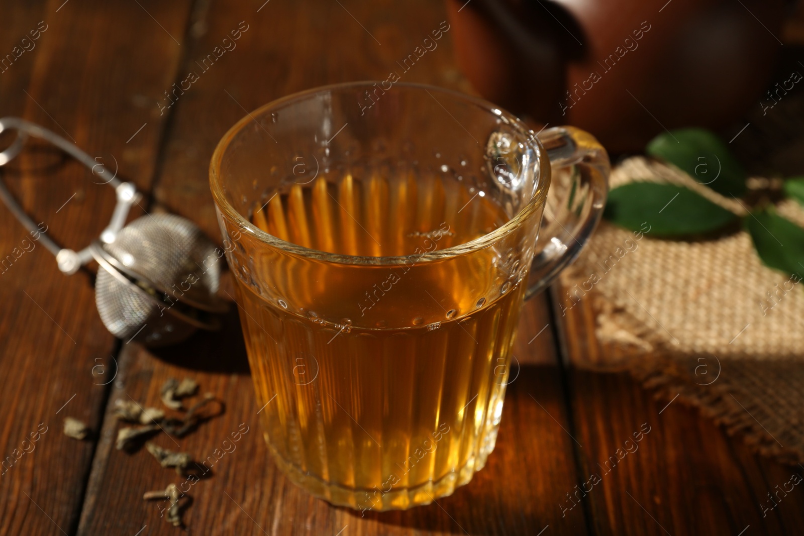 Photo of Refreshing green tea in cup on wooden table, closeup