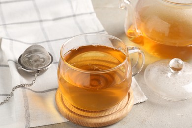 Refreshing green tea and strainer on textured table, closeup