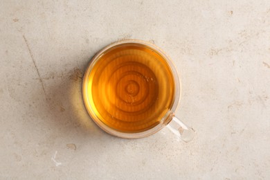 Photo of Refreshing green tea in cup on light textured table, top view