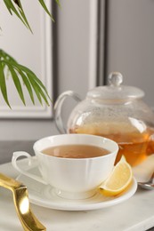 Photo of Refreshing green tea and slice of lemon on tray, closeup