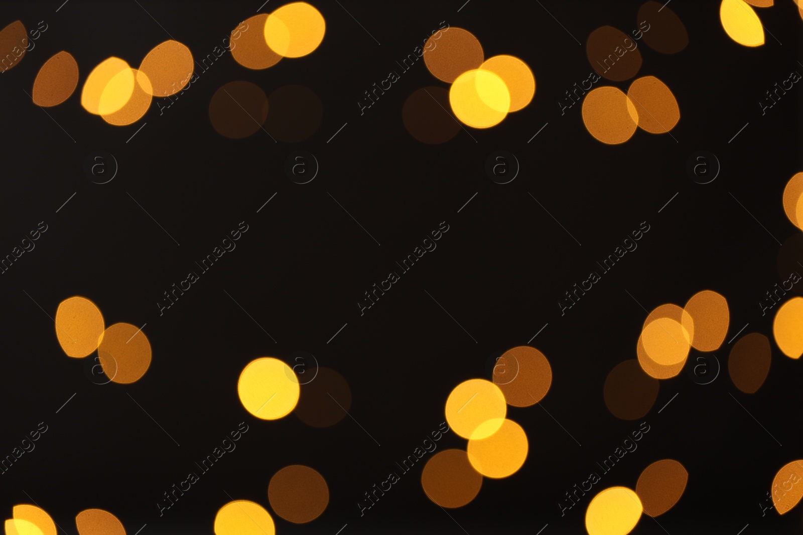 Photo of Blurred view of golden lights on black background, bokeh effect