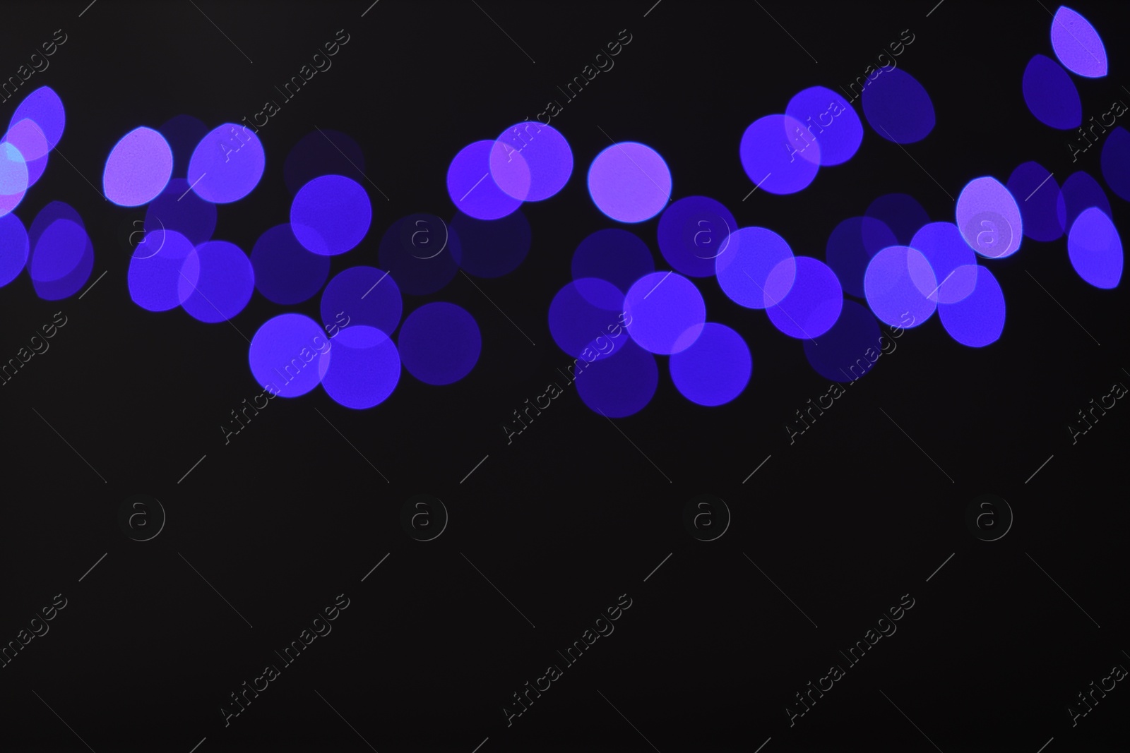 Photo of Blurred view of colorful lights on black background, bokeh effect