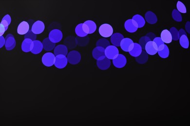 Photo of Blurred view of colorful lights on black background, bokeh effect