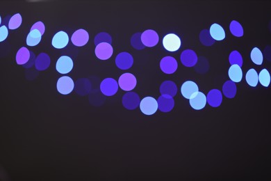 Photo of Blurred view of colorful lights on black background, bokeh effect