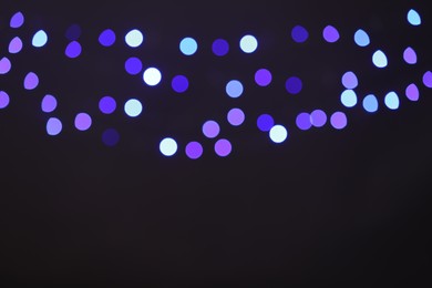 Photo of Blurred view of colorful lights on black background, bokeh effect