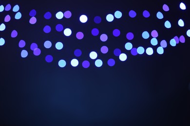 Photo of Blurred view of colorful lights on dark blue background, bokeh effect