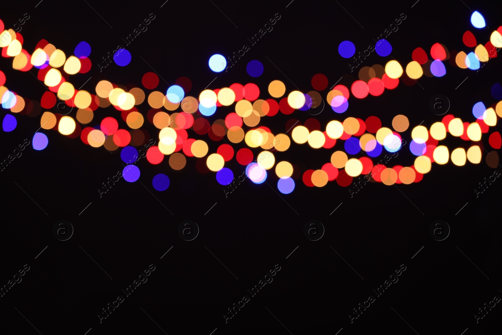 Photo of Blurred view of colorful lights on black background, bokeh effect