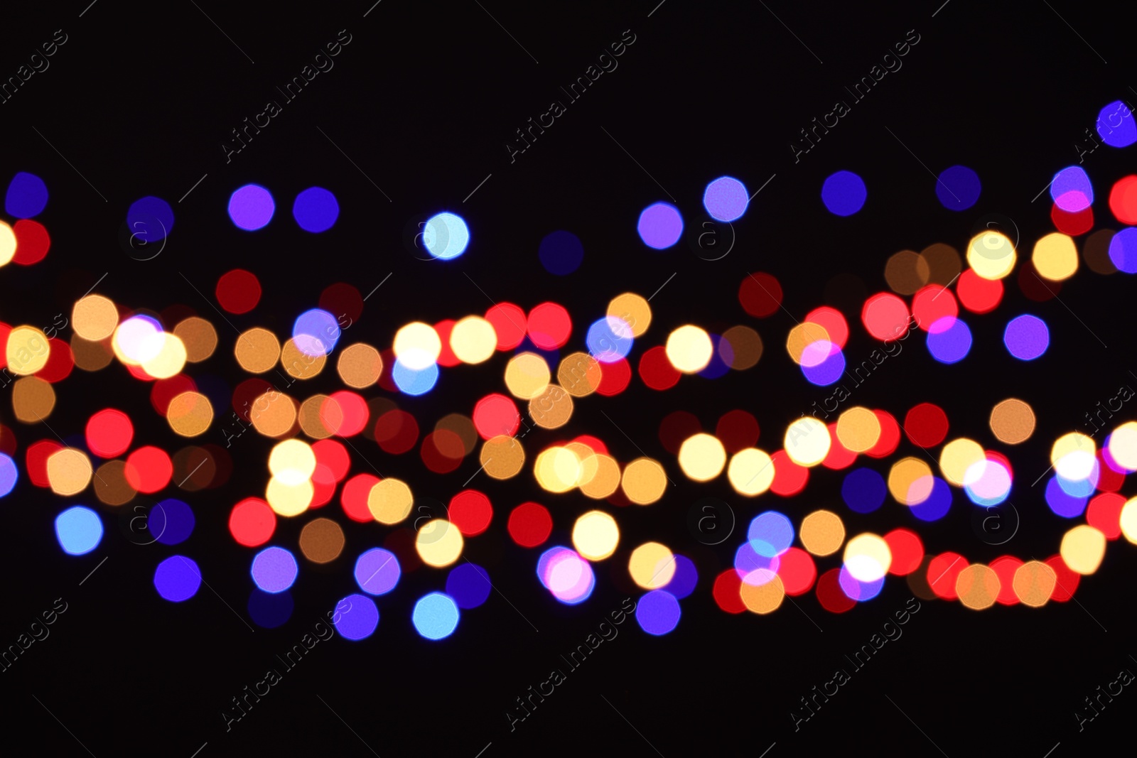 Photo of Blurred view of colorful lights on black background, bokeh effect