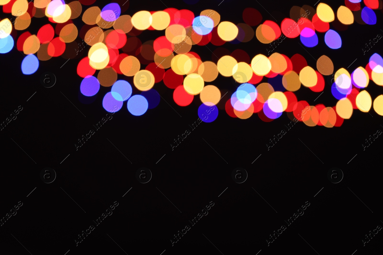 Photo of Blurred view of colorful lights on black background, space for text. Bokeh effect