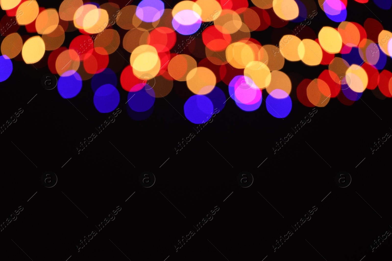 Photo of Blurred view of colorful lights on black background, space for text. Bokeh effect