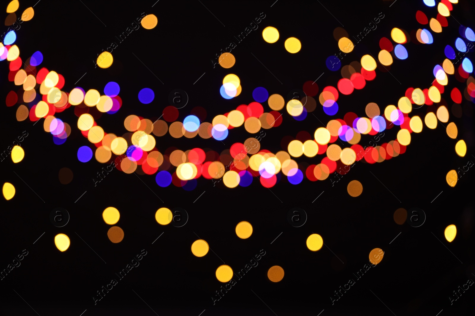 Photo of Blurred view of colorful lights on black background, bokeh effect