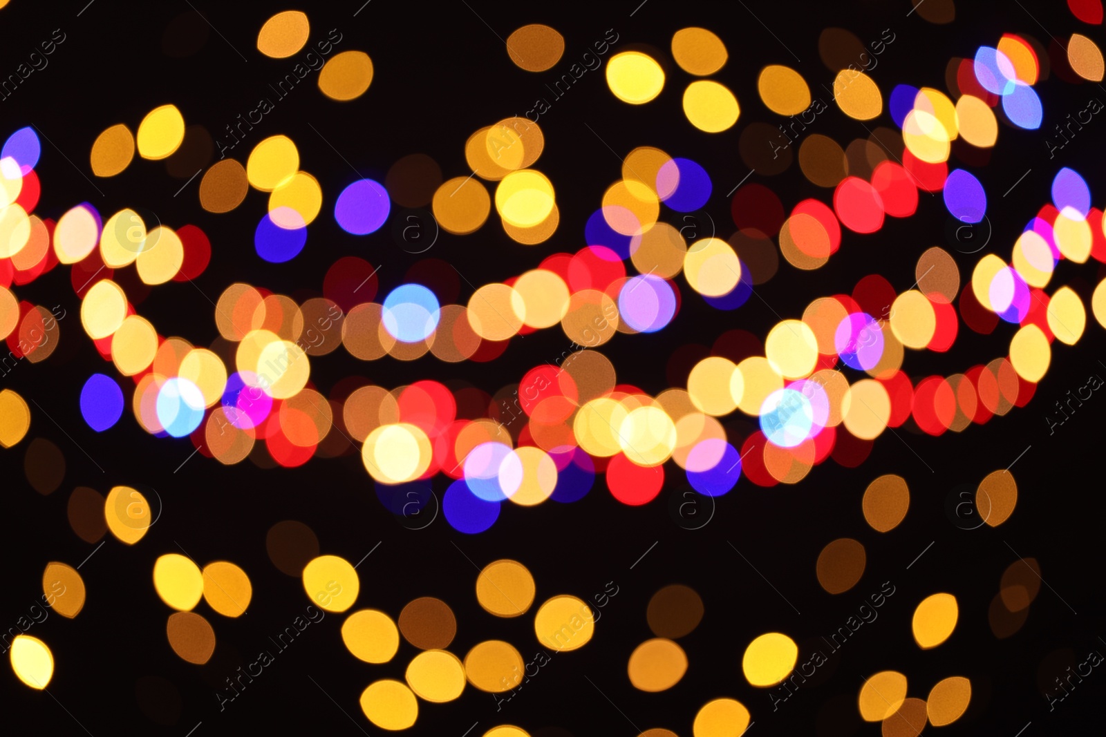 Photo of Blurred view of colorful lights on black background, bokeh effect