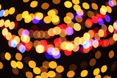 Photo of Blurred view of colorful lights on black background, bokeh effect