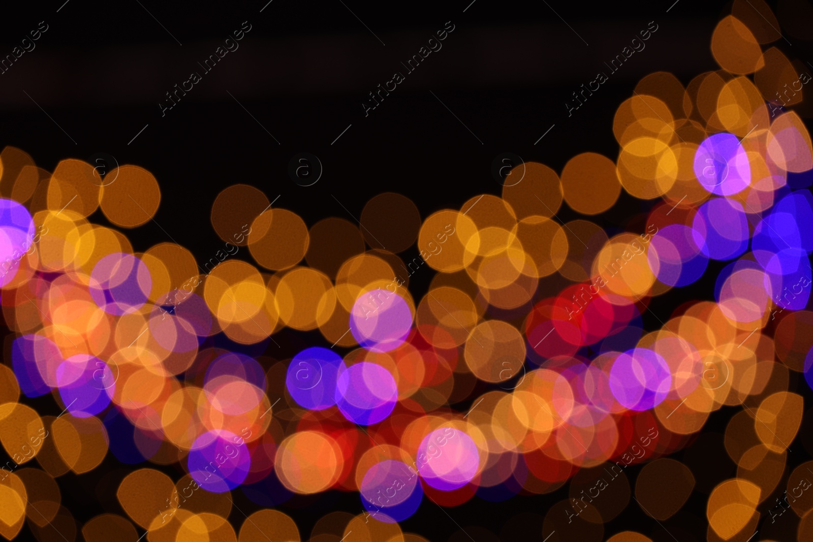 Photo of Blurred view of colorful lights on black background, bokeh effect