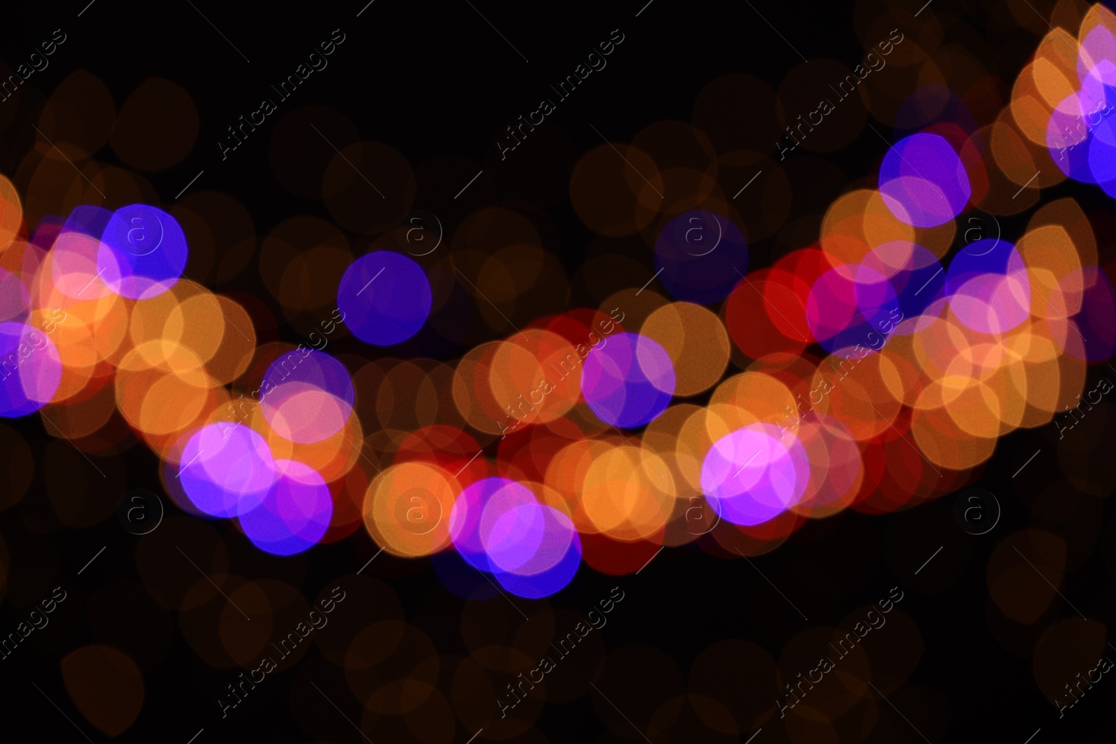 Photo of Blurred view of colorful lights on black background, bokeh effect