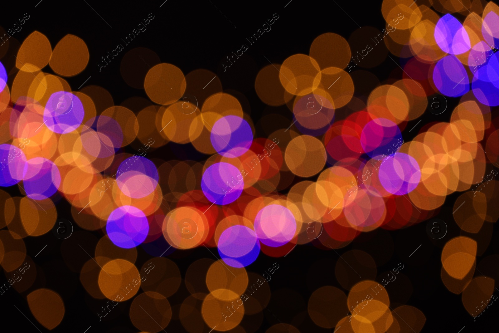 Photo of Blurred view of colorful lights on black background, bokeh effect