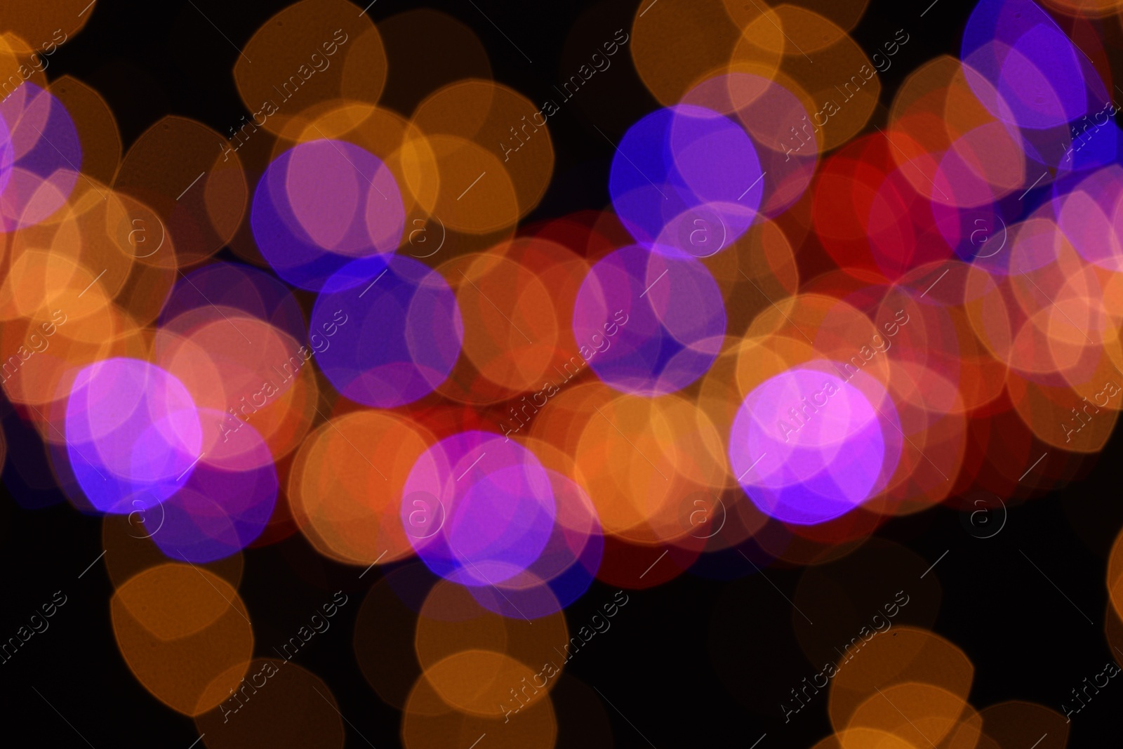 Photo of Blurred view of colorful lights on black background, bokeh effect