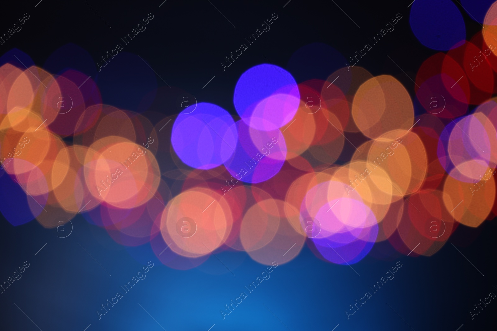 Photo of Blurred view of colorful lights on dark blue background, bokeh effect