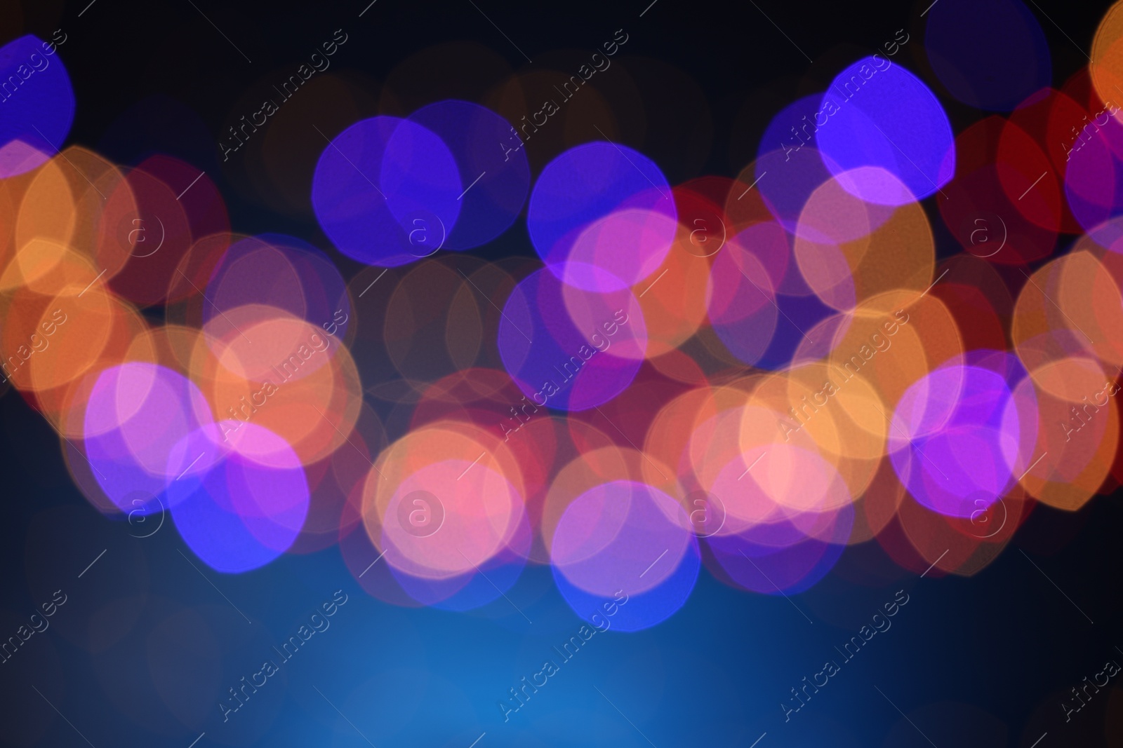 Photo of Blurred view of colorful lights on dark blue background, bokeh effect