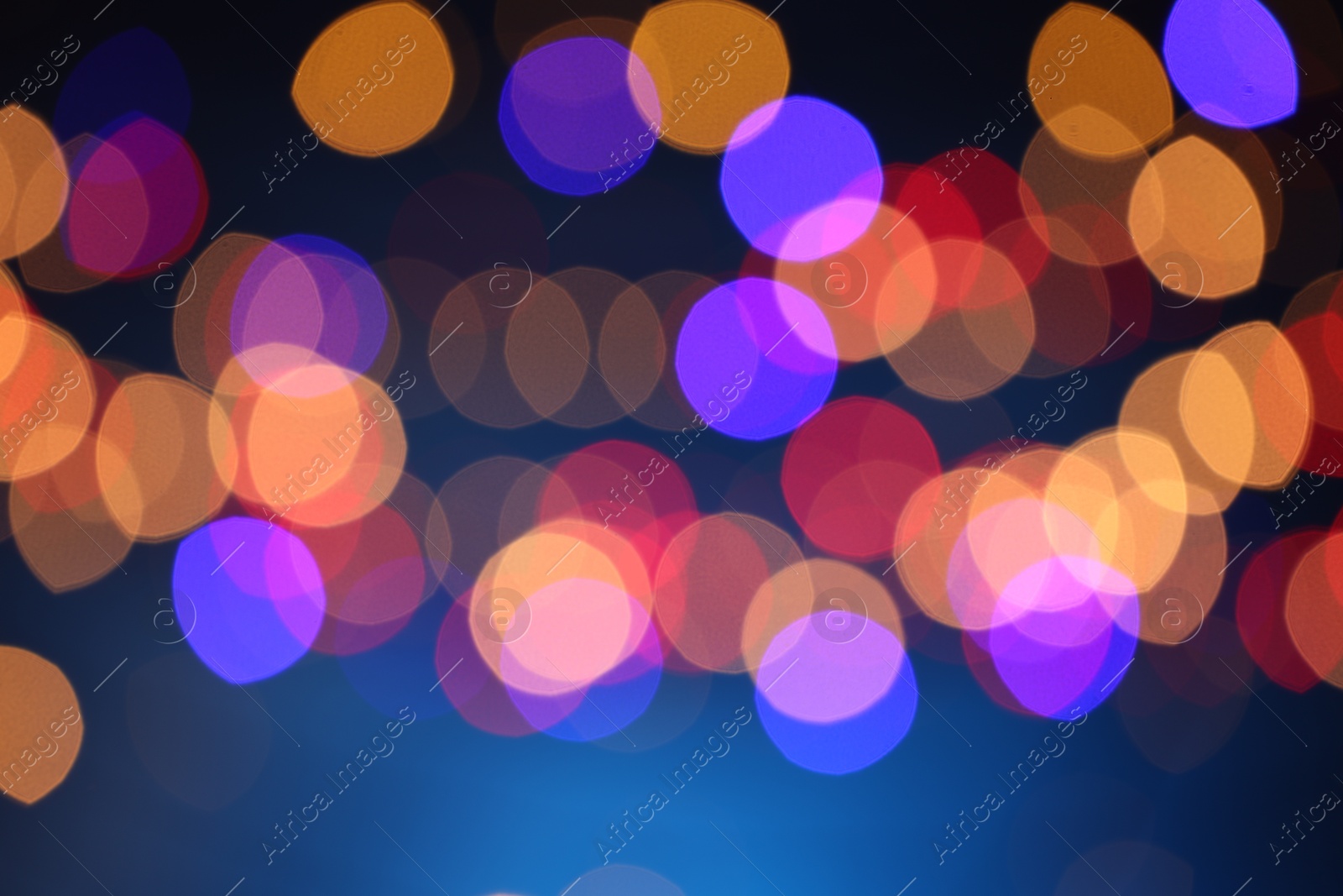 Photo of Blurred view of colorful lights on dark blue background, bokeh effect