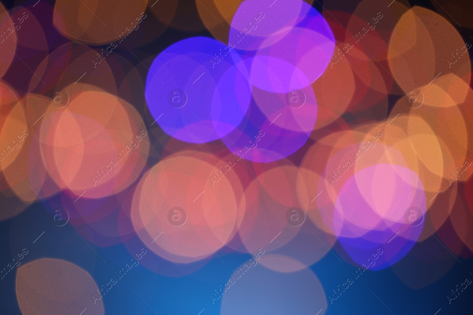 Photo of Blurred view of colorful lights on dark blue background, bokeh effect