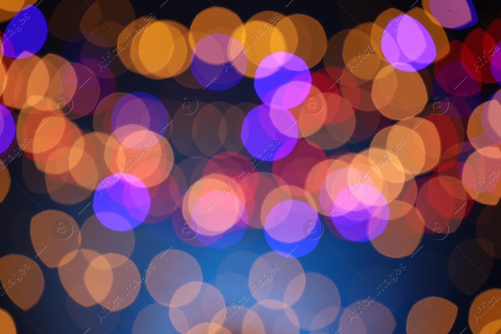 Photo of Blurred view of colorful lights on dark blue background, bokeh effect