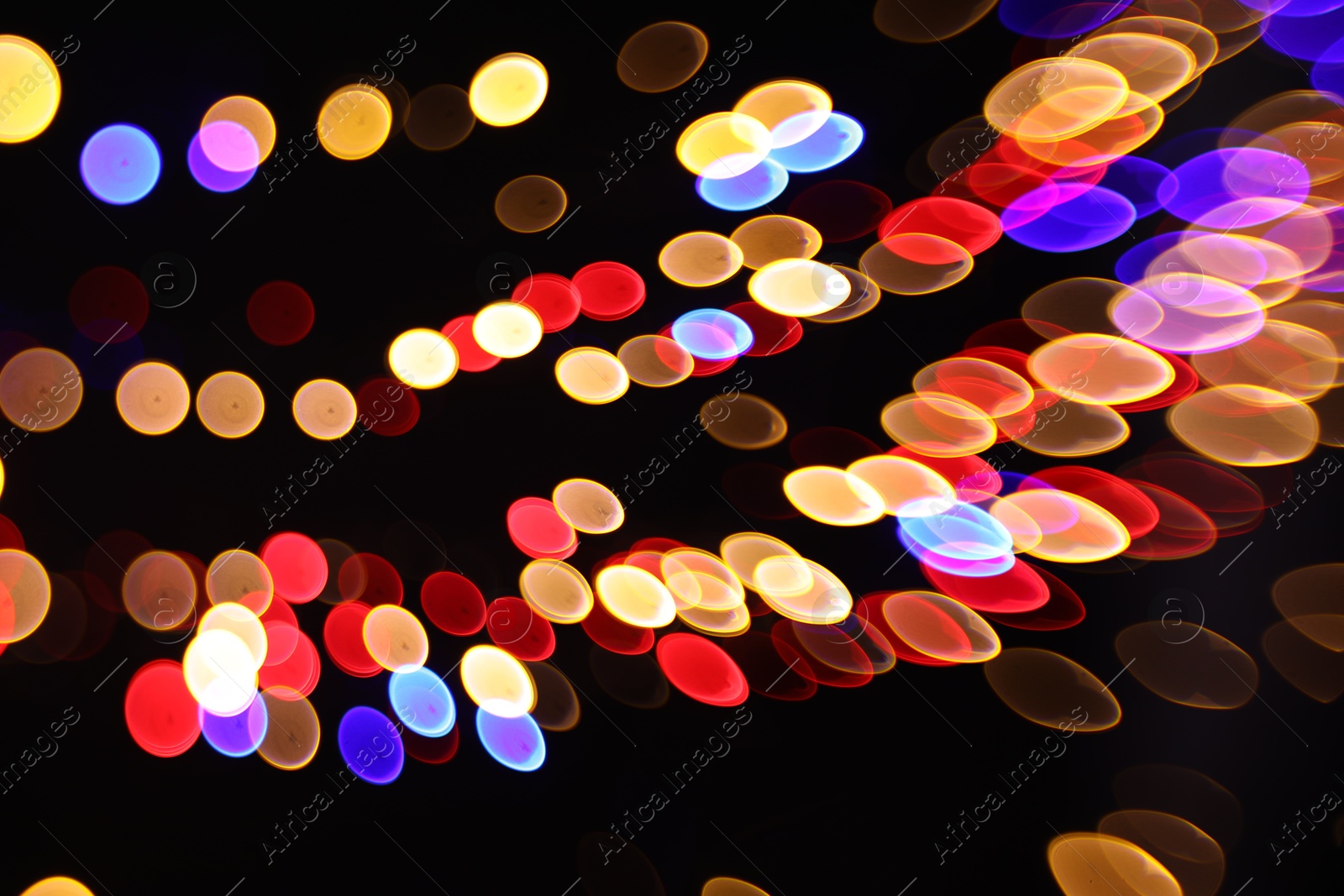 Photo of Blurred view of colorful lights on black background, bokeh effect