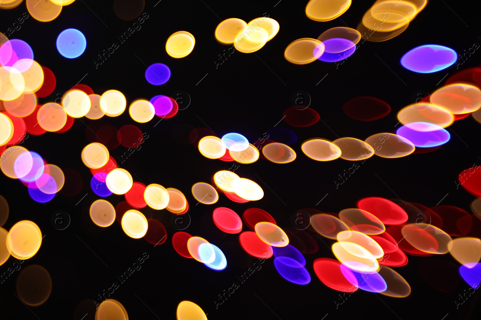 Photo of Blurred view of colorful lights on black background, bokeh effect