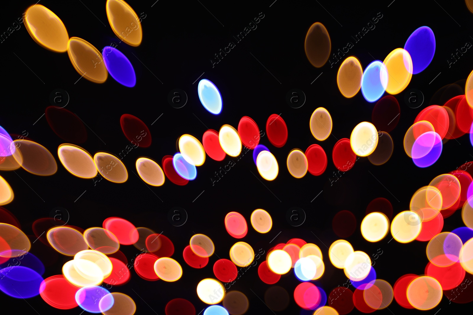 Photo of Blurred view of colorful lights on black background, bokeh effect