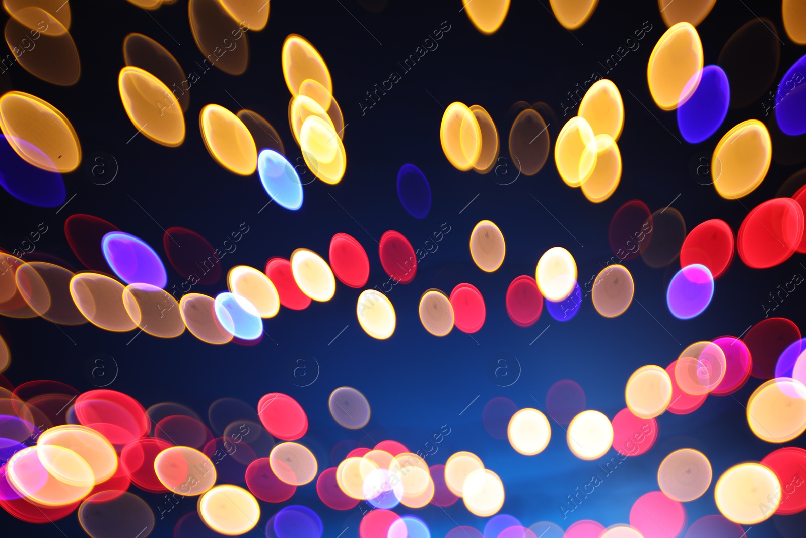 Photo of Blurred view of colorful lights on dark blue background, bokeh effect