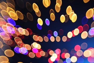 Photo of Blurred view of colorful lights on dark blue background, bokeh effect