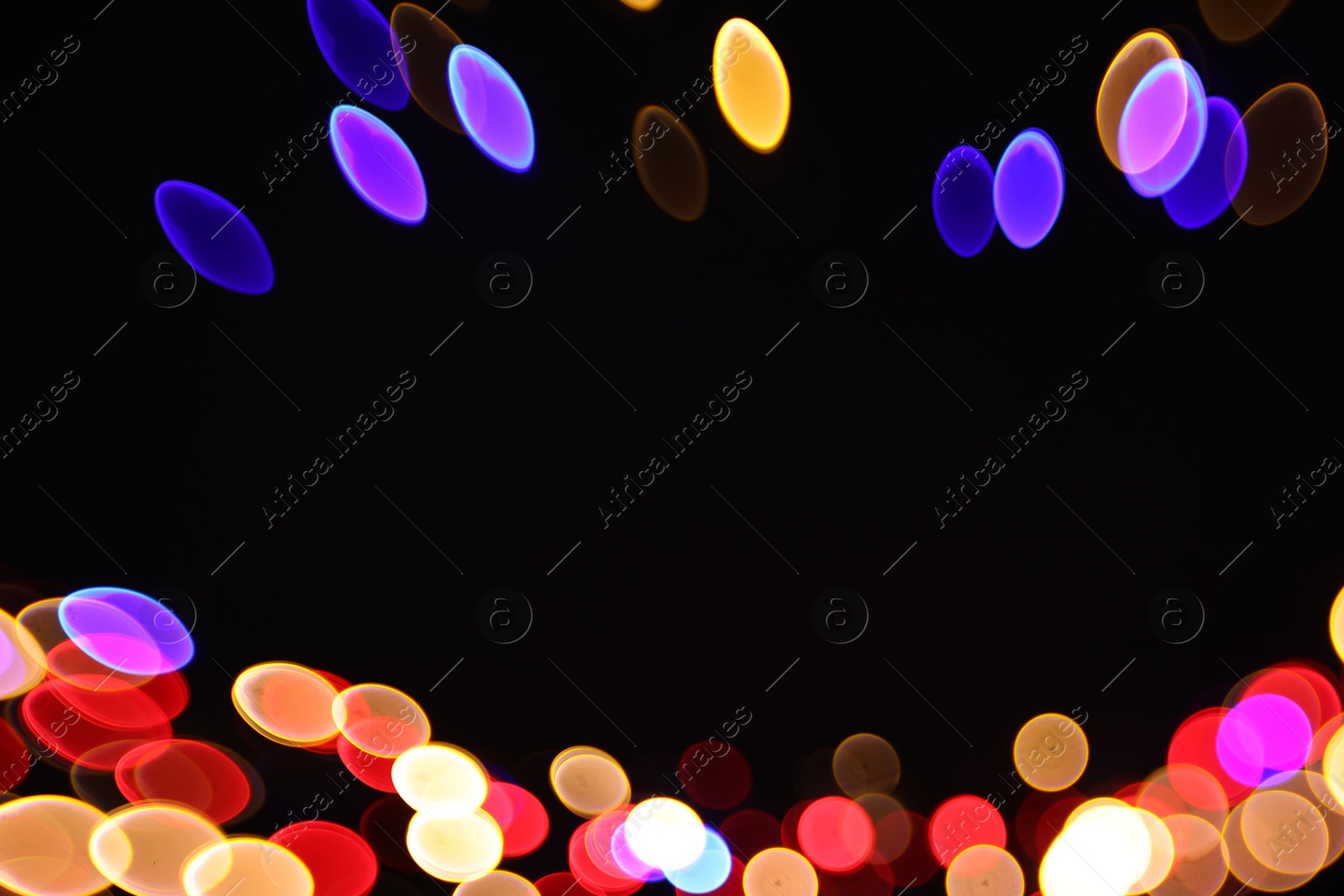 Photo of Blurred view of colorful lights on black background, space for text. Bokeh effect