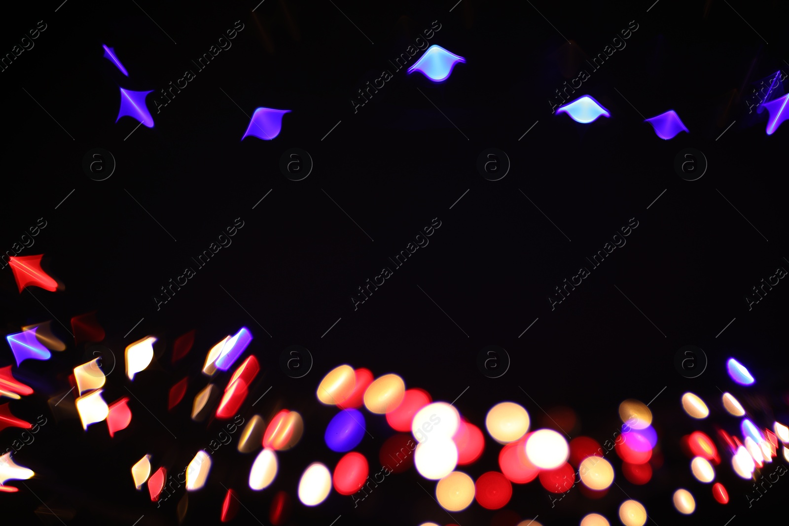 Photo of Blurred view of colorful lights on black background, space for text. Bokeh effect