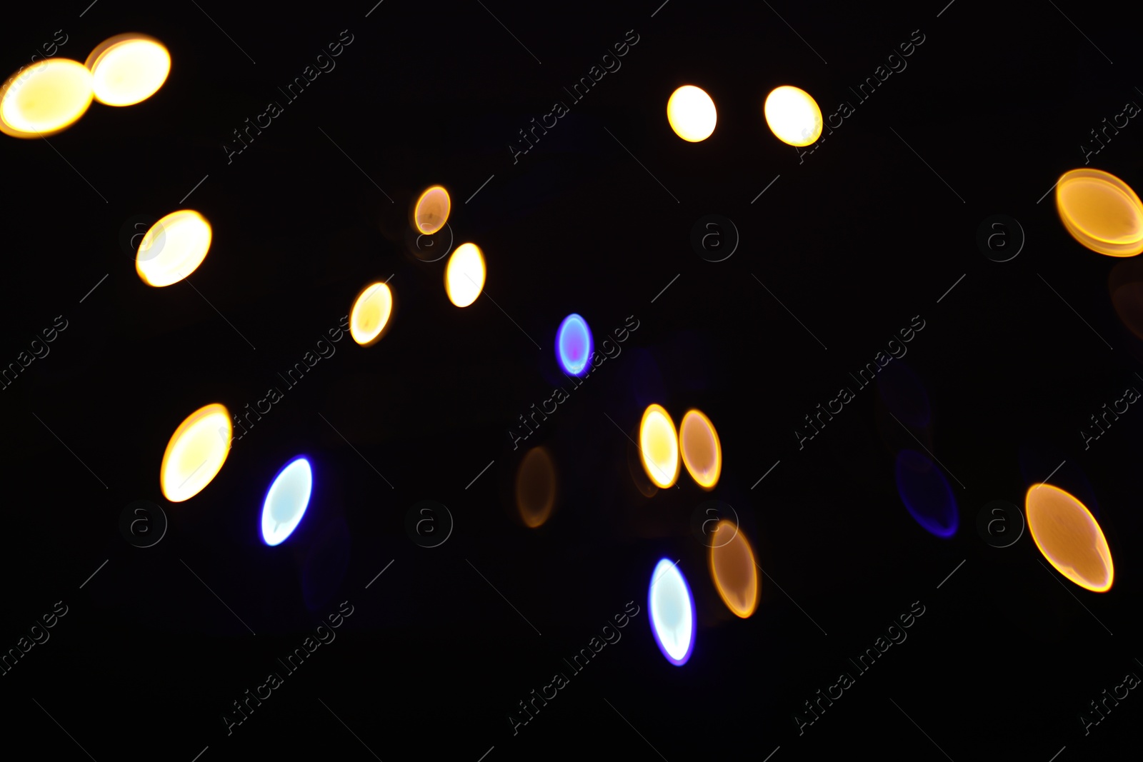 Photo of Blurred view of colorful lights on black background, bokeh effect