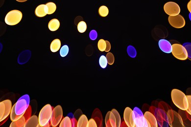 Photo of Blurred view of colorful lights on black background, bokeh effect