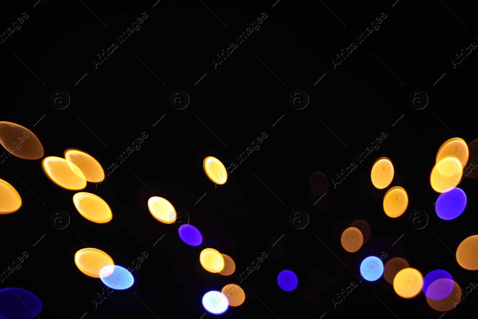 Photo of Blurred view of colorful lights on black background, bokeh effect