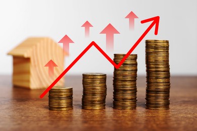 Real estate market. Stacked coins and arrows on wooden table, interest rate rise