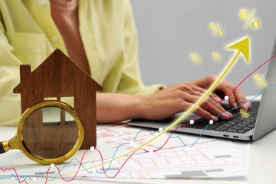 Image of Real estate market. Woman using laptop, closeup. Graphic, arrow and house model visualizing interest rate rise