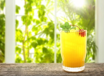 Image of Tasty pineapple cocktail in glass on wooden table indoors. Space for text