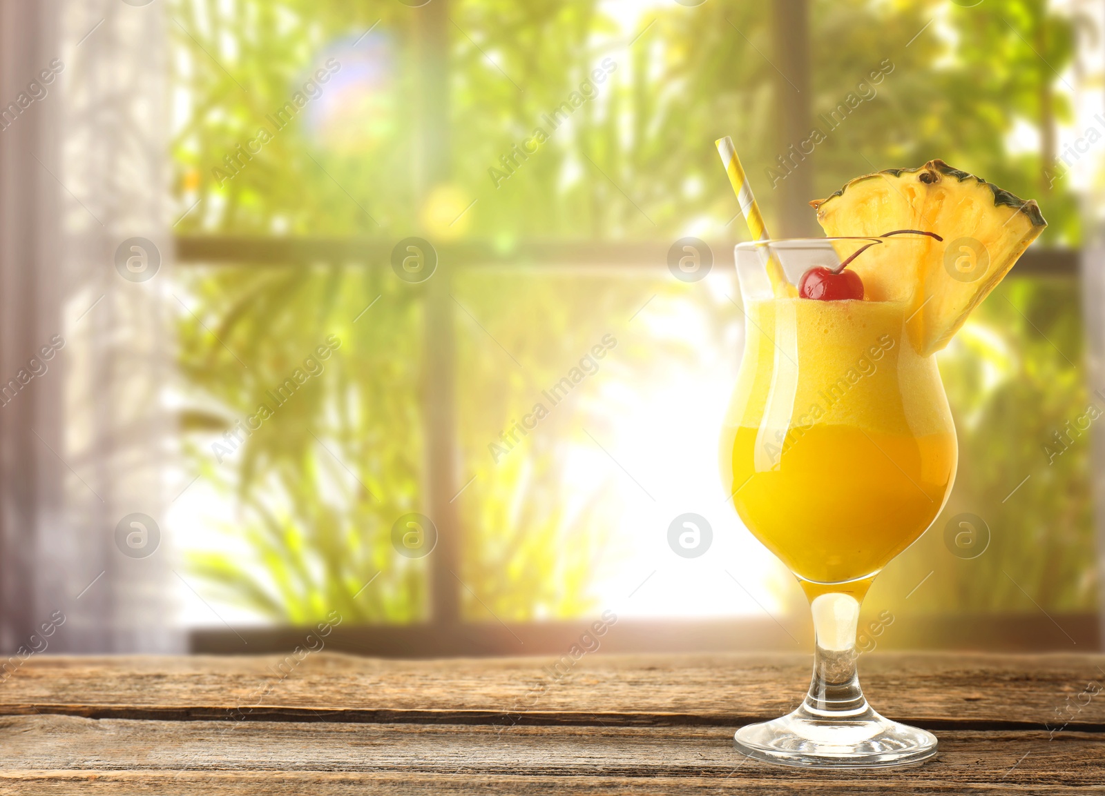 Image of Tasty pineapple cocktail in glass on wooden table indoors. Space for text